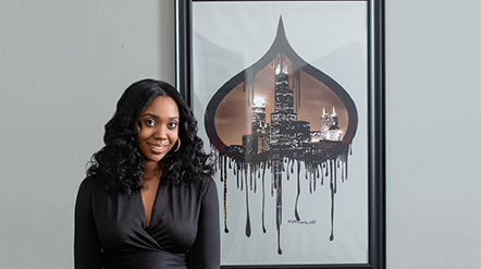 Next Gen MBA student Nikiya Price smiling next to a piece of art.